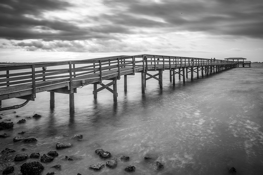 FL Insurance News - Black and White Photo of a Peir Extending Out Into the Ocean on a Cloudy Day